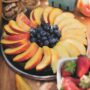 Naturally-gluten free citrus olive oil cake covered with fresh peaches and blueberries