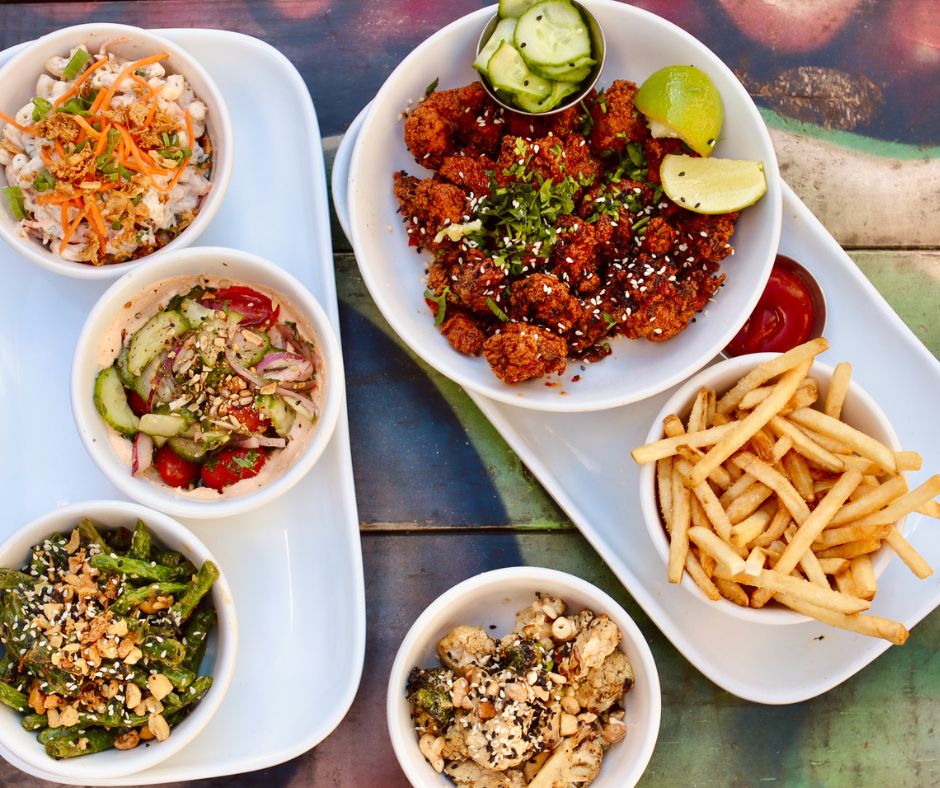  Assorted dishes including fried chicken, salads and fries served on a table.