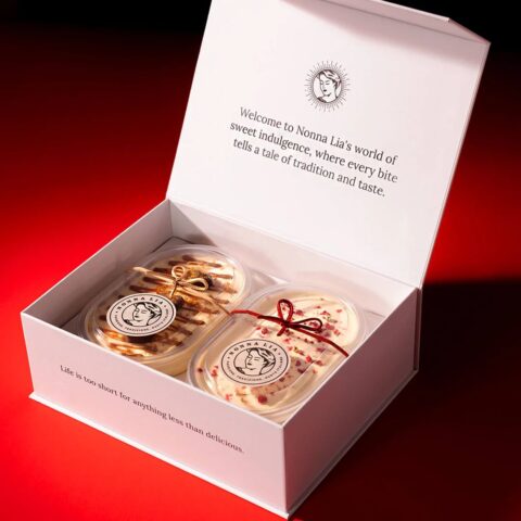 A white box open to show two containers of tiramisu.