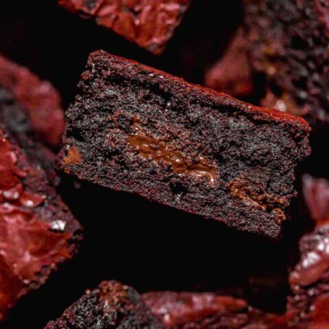 Close-up of a fudgy red velvet brownie showing its dense, chocolate-filled centre