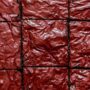 Overhead view of red velvet brownies with a glossy, crinkled top cut into squares