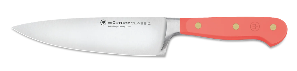 A chef's knife with a coral-coloured handle.
