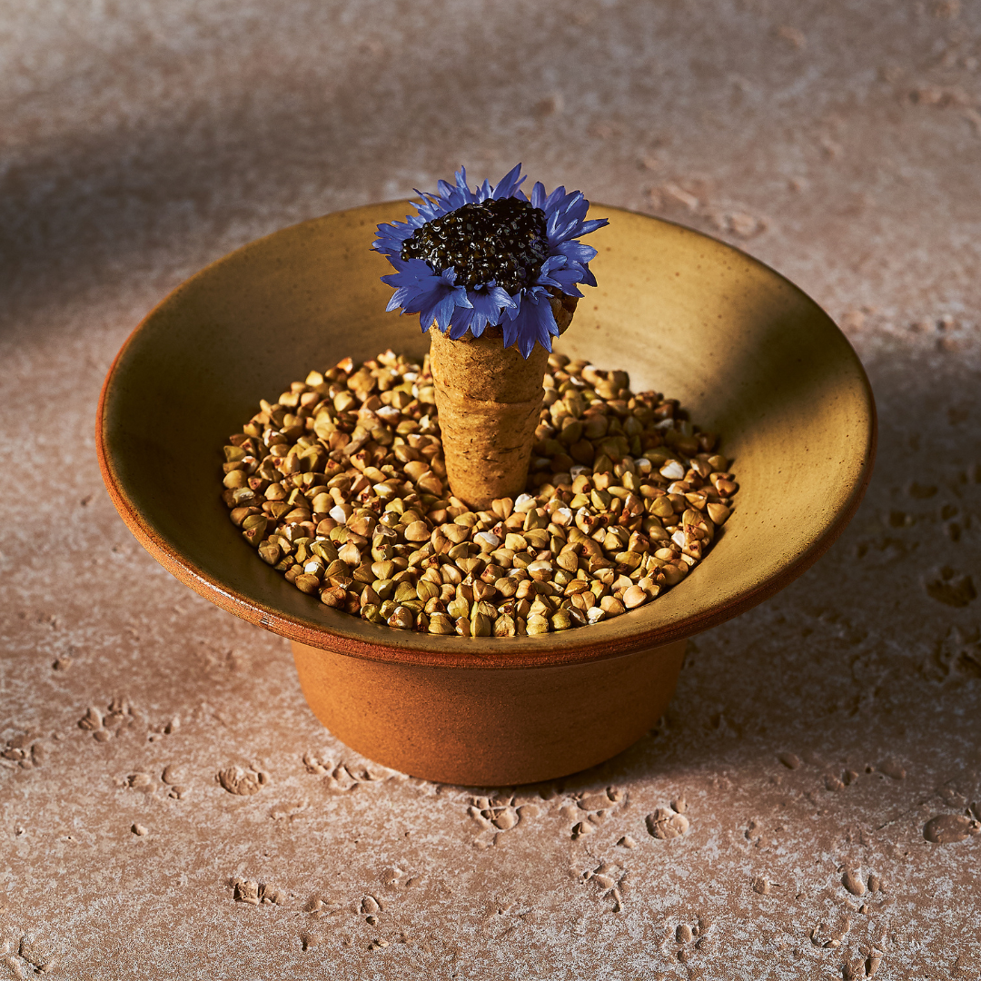 A cone of caviar with decorative blue flowers. 