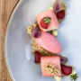 Rhubarb and ice cream on a white speckled plate.
