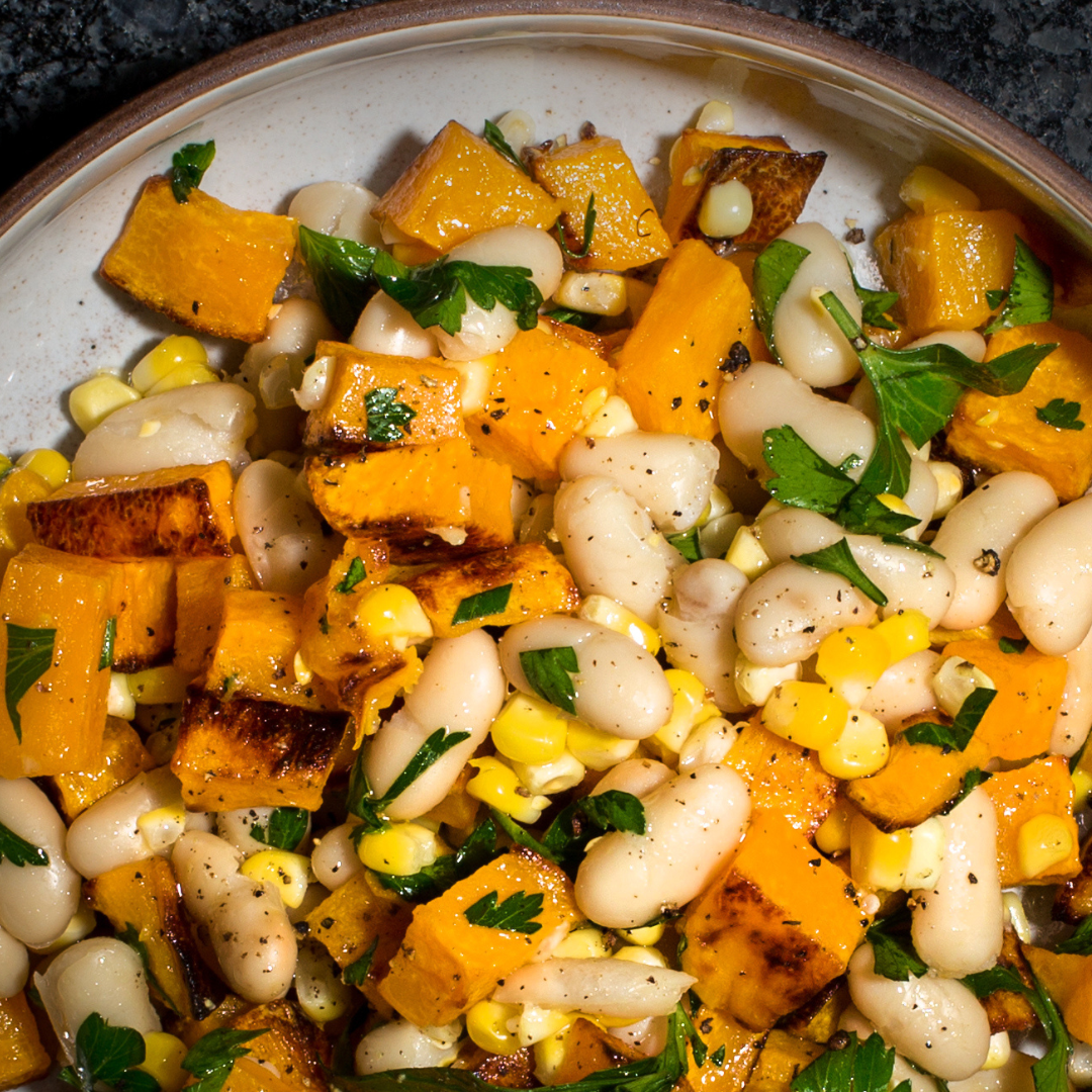 Close-up of a salad with squash, beans and corn.