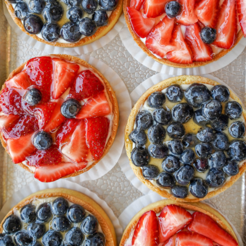 Overhead shot of mini strawberry and blueberry tarts.