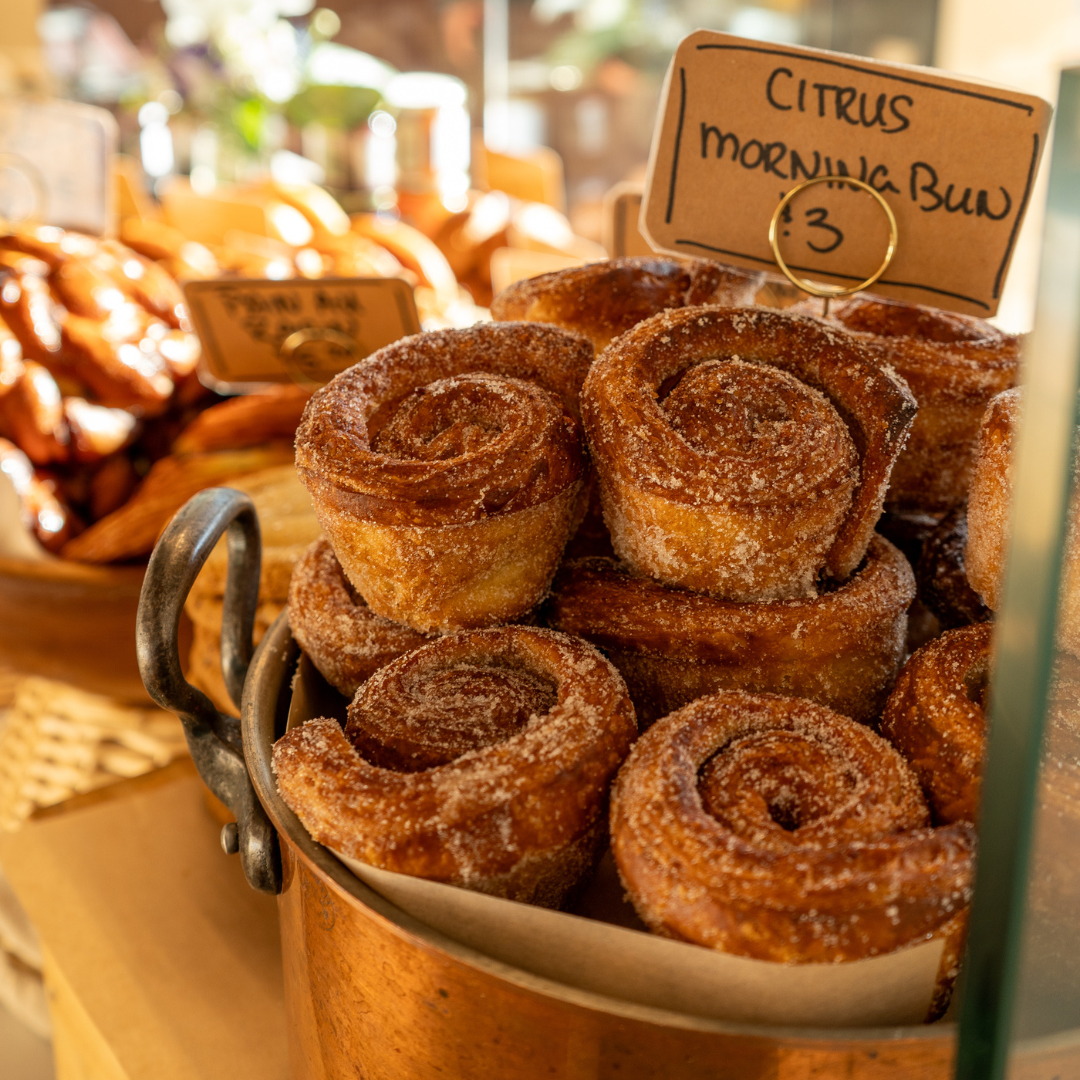 A pile of citrus morning buns on a pastry counter. 
