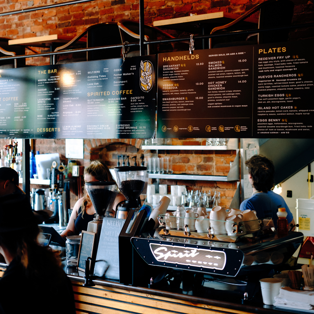 Interior of a coffeeshop with black menus hanging above the bar.