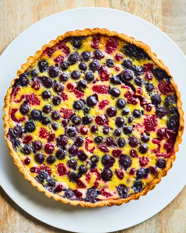 Cherry and berry clafoutis tart with sweet-tart cherries, blueberries and baked vanilla custard in a buttery pastry shell.