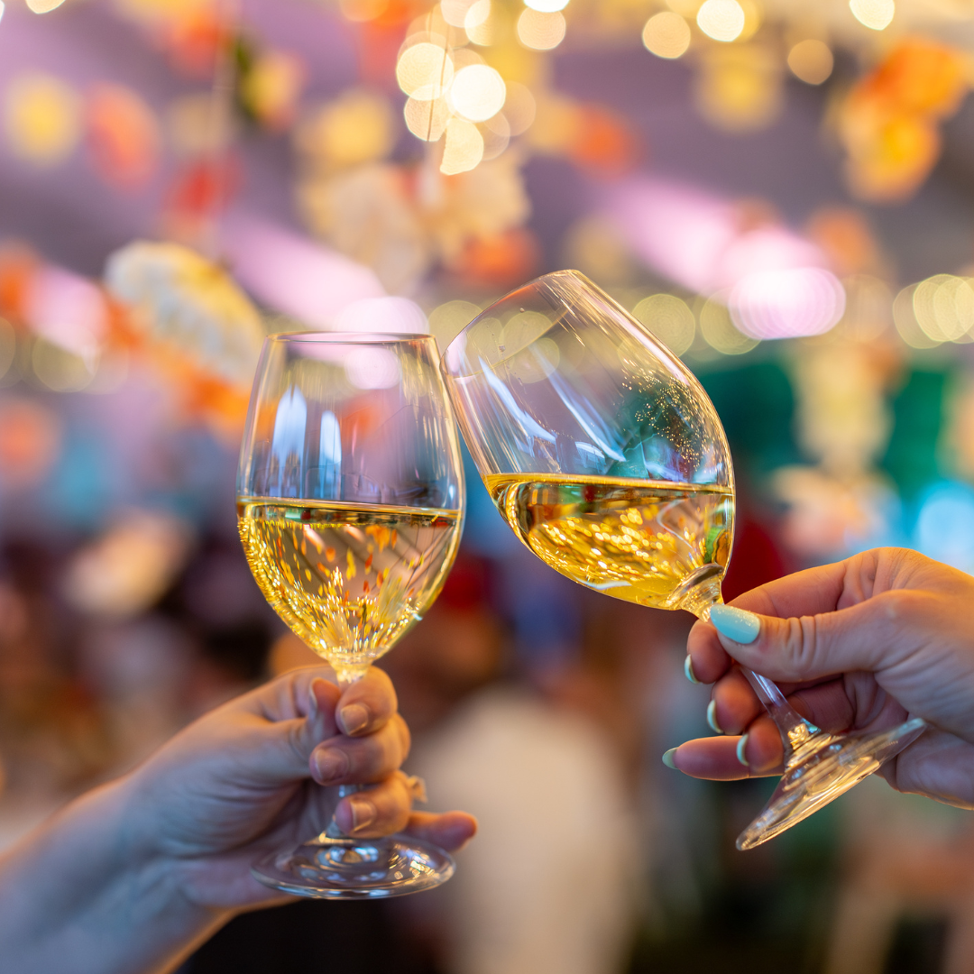 Two glasses of Chardonnay cheersing.